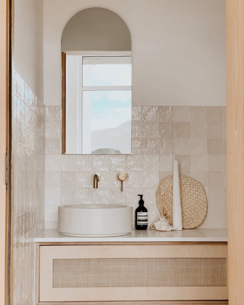 Badkamer met wastafel in natuurlijke stijl met ovale spiegel