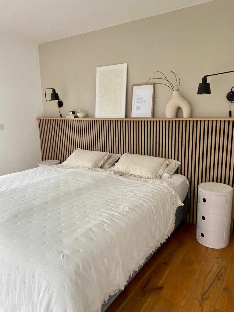 Slaapkamer met houten panelen en een plankje boven het bed 