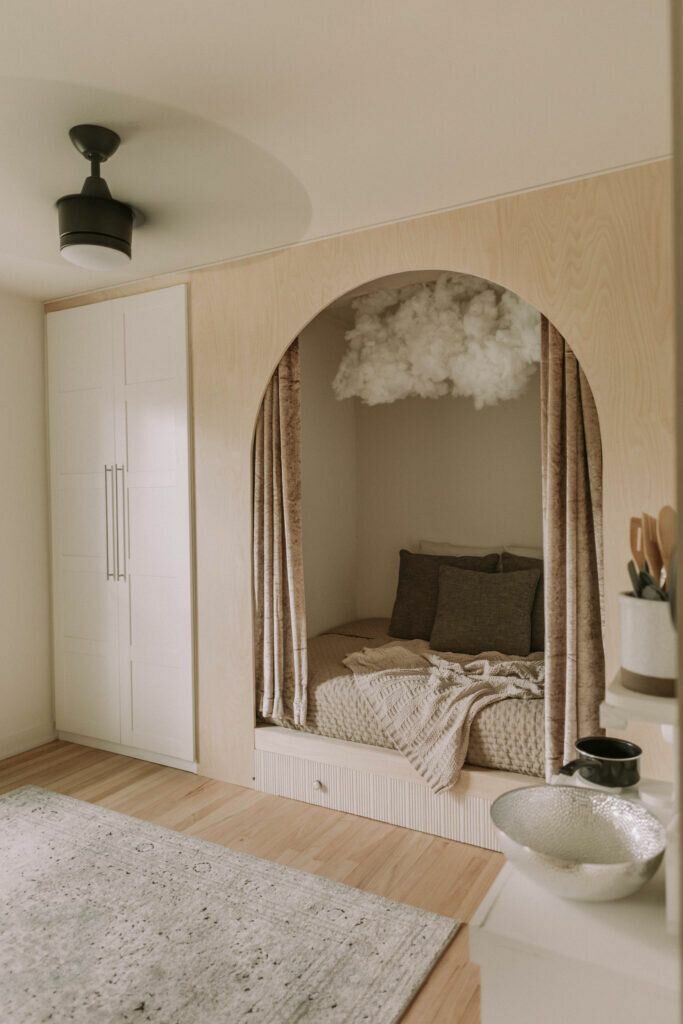 Een kinderslaapkamer met boogvormige nis en bed 