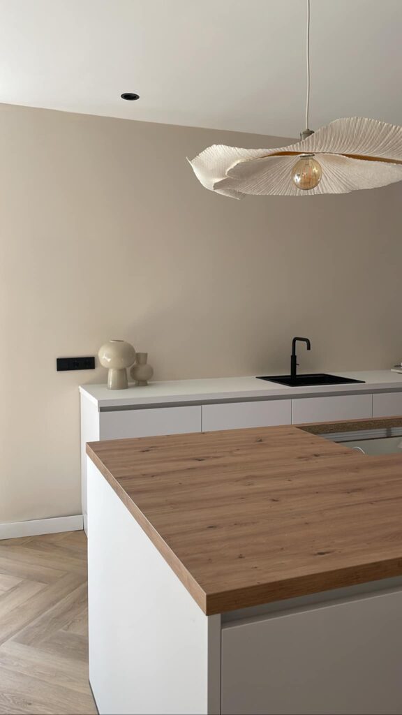 Een witte keuken met een houten werkblad
