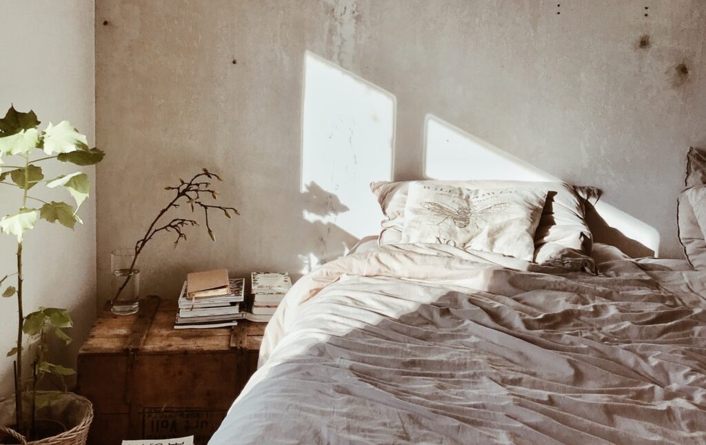een slaapkamer met beige dekbed en japandi accessoires