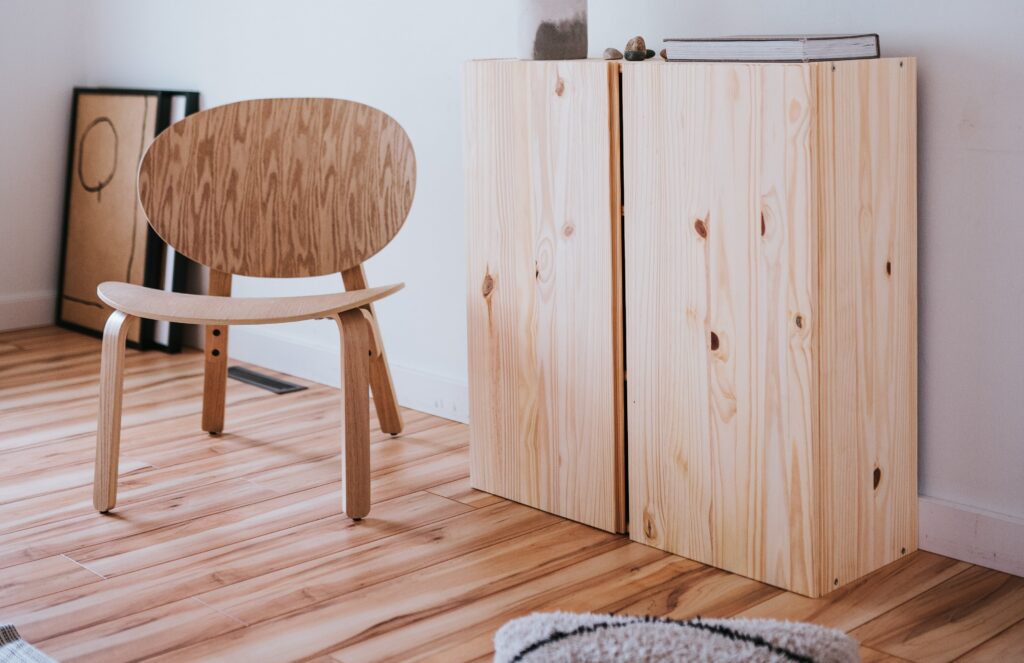 Een woonkamer met een grenen kast en design stoel